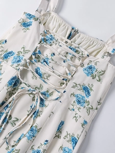Detailansicht der Rückseite des weißen Blumenkleides mit blauem Rosendruck und Schnürung