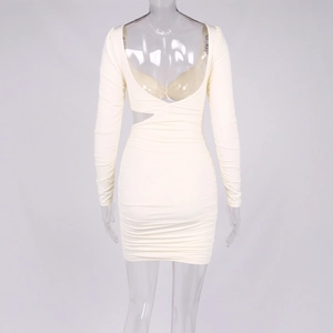 Détail de la robe courte crème froncée à manches longues avec découpe latérale et dos nu