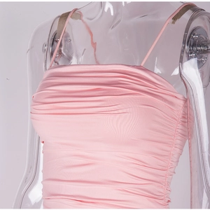 Detailed close-up of light pink ruched fabric texture on a slim fit summer slip dress