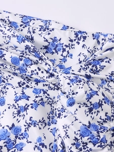 Detail of blue floral print on white fabric with central twist knot and pleated texture
