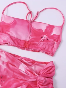 Close-up of pink floral two-piece set featuring adjustable straps and knotted ruched side