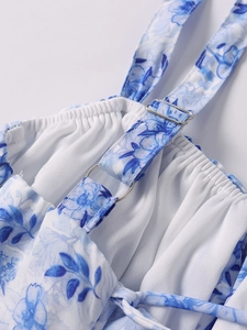 Detail eines verstellbaren Schultergurts mit Metallschnalle am floralen Sommerkleid