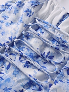 Detail des blau geblümten Sommerkleids mit Schnürung am Rücken und feiner Nahtverarbeitung