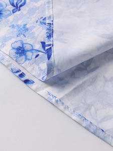 Detailaufnahme des blauen Porzellanmusters auf weißem Stoff mit sauberem Doppelsaum