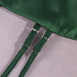 Detail of dark green satin dress showing adjustable dual thin straps and silver buckles