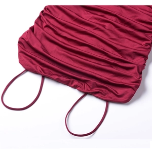 Detail of wine red pleated dress showing thin straps and smooth satin fabric texture