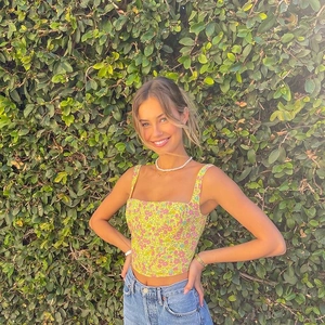 Detail of yellow floral corset top with square neck and slim fit on a model outdoors