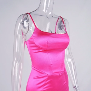 Detail of hot pink satin slip dress featuring slender straps and lustrous fabric finish