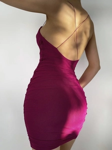Detail of rose red ruched mini dress showing backless cross-strap design and bodycon fit