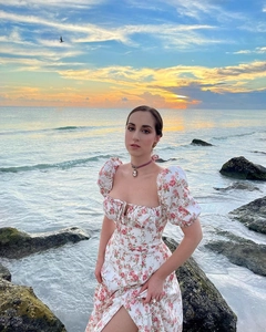Detail of floral French slit dress with puff sleeves and square neck in sunset setting