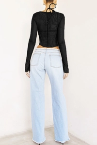 Vue de dos d'un haut corset sexy en mesh noir avec fermeture éclair et jean en denim