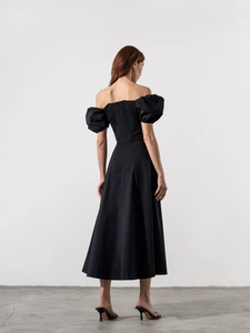 Elegante vista posteriore dell'abito lungo nero con spalle scoperte e maniche a sbuffo