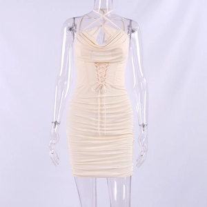 Detail view of cowl neck and cross-strap waist design on beige ruched mini dress