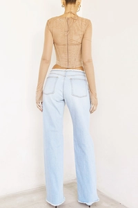 Détail du haut en résille avec fermeture éclair cachée et taille en denim à bords effilochés