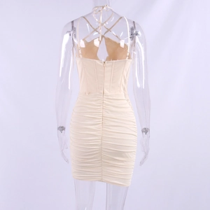 Back view of a beige ruched mini dress with crisscross lace-up halter and backless design