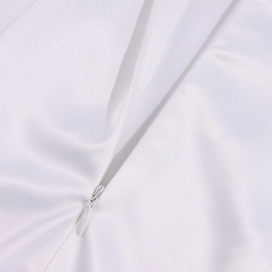Detail of invisible zipper on high-quality white satin dress showing smooth fabric texture