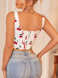 Detail of white floral crop top featuring red cherry print and back metal zipper