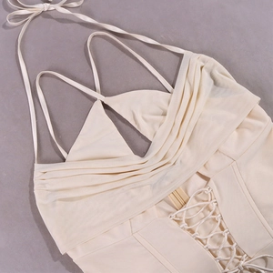 Detail of cream mesh corset mini dress with crisscross pleats and tie-waist design