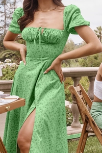 Detailed shot of floral green dress featuring square neck and puff sleeves with side slit