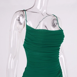 Detail of dark green ruched mesh dress showing thin straps and slim fit texture