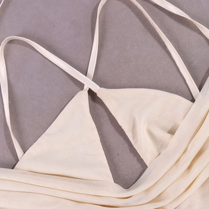 Detailed close-up of beige mesh fabric featuring crisscross straps and fine pleated texture