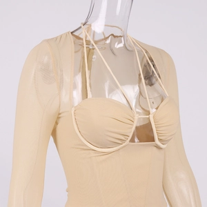 Détail des manches en mesh transparent et lanières croisées d'un body beige cintré