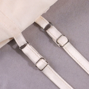 Detail of adjustable silver metal rings and buckles on off-white mesh fabric strap