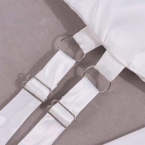 Macro detail of adjustable silver hardware on white satin dress spaghetti straps
