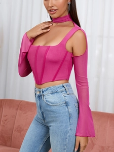 Dettaglio del top a corsetto in rete rosso rosa con maniche velate e scollo