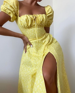 Detail of yellow floral dress featuring puff sleeves and square neckline with drawstring
