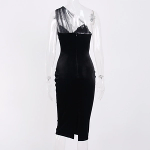 Detailed back view of a black velvet midi dress with sheer mesh shoulder and split hem