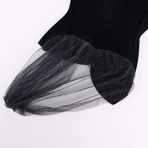 Close-up of black velvet dress featuring glittery mesh sheer details and pleated texture