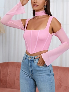 Dettaglio del top a corsetto rosa con maniche a rete e jeans in denim blu da donna