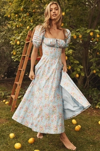 Detail of light blue floral dress with puff sleeves and square neckline in a lemon grove