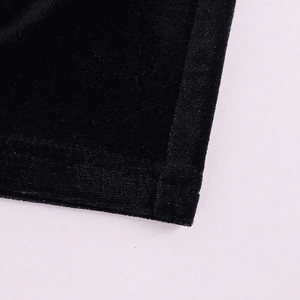 Detail of black velvet fabric showing soft texture and professional flatlock stitching