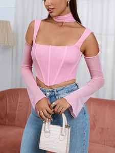 Dettaglio del top a corsetto rosa con maniche a rete, spalle scoperte e cinturino al collo