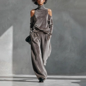 Detail of taupe velvet tracksuit showing off-shoulder high neck top and wide leg pants
