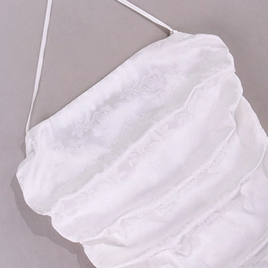 Gros plan d'une robe licou en satin blanc avec tissu jacquard et détail de col drapé