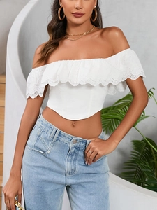 Dettaglio top corto bianco con spalle scoperte, ricamo inglese e volant decorativi