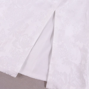 Détail d'une robe en jacquard floral blanc montrant la fente et la couture fine