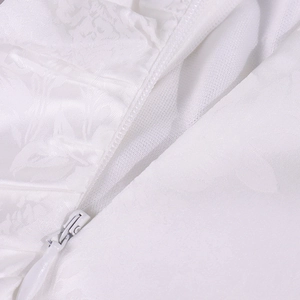 Détail du tissu jacquard blanc avec fermeture éclair invisible et motifs floraux fins