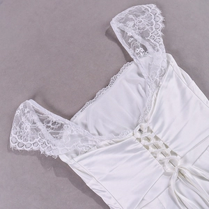 Detail of white satin dress featuring intricate lace shoulder straps and lace-up back design
