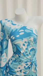 Dettaglio del vestito con stampa geometrica blu e bianca con nodo e drappeggio