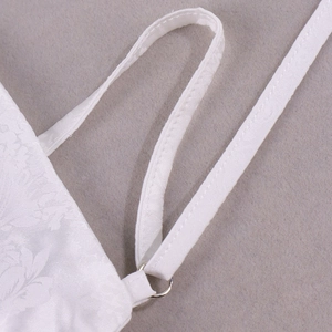 Détails macro du tissu satin jacquard blanc avec motifs roses et anneaux en métal