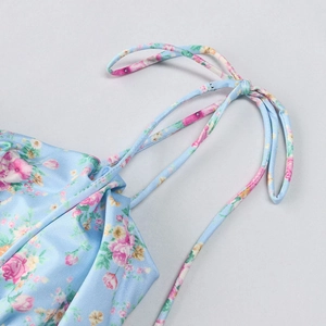 Close-up of thin adjustable tie straps on a light blue floral print maxi dress
