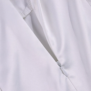 Close-up of white invisible zipper on back of a square neck satin cocktail dress