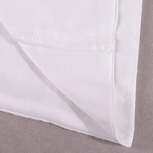 Gros plan sur le tissu jacquard blanc montrant la texture en relief et les coutures