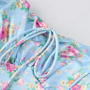 Detail of floral backless maxi dress featuring drawstring pleats and pink rose patterns
