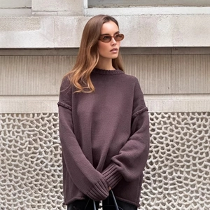 Close-up of plum oversized knit sweater showing ribbed cuffs and thick fabric texture
