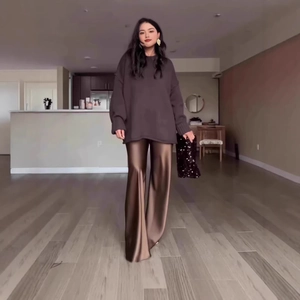 Close-up of elegant bronze satin wide-leg trousers paired with a charcoal grey knit sweater